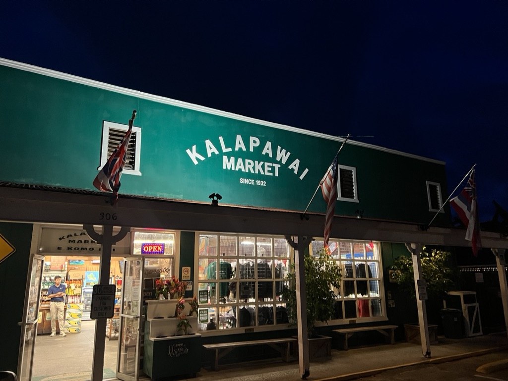 Kalapawai Market’s green storefront lit before sunrise